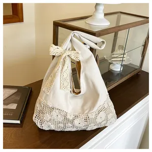 Detail of canvas tote bag with exquisite lace trim and a large decorative bow