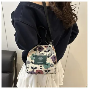 Détails du tissu jacquard floral et de l'étiquette carrée sur le sac seau à bandoulière