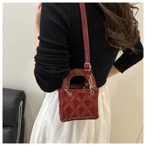 Mannequin portant un sac matelassé bordeaux en cuir verni avec des accessoires dorés