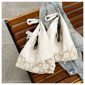 Detail of cotton canvas tote bag featuring intricate floral crochet and lace bow detail