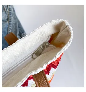 Close-up of woven tote bag with silver zipper closure and wavy colorful pattern