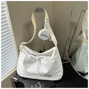 Detail of cream tote bag featuring drawstring pocket and round detachable coin purse