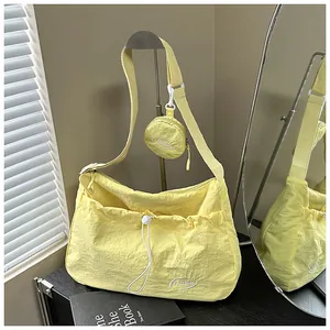 Detail of light yellow nylon tote bag with drawstring pocket and small round coin purse