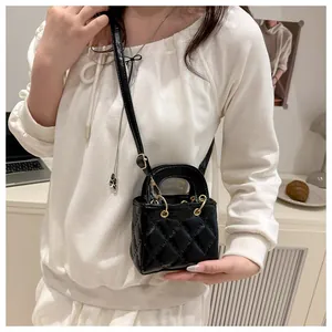 Détail d'un mini sac bandoulière noir matelassé en similicuir avec anneaux dorés