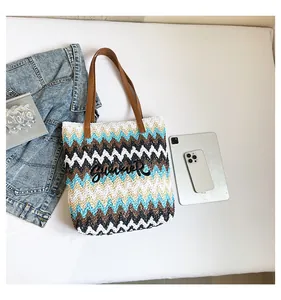 Macro view of woven tote with chevron stripes, summer embroidery and leather handle
