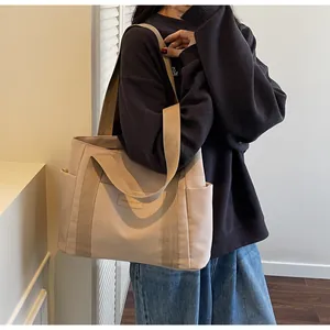 Dettaglio della borsa tote in tela con etichetta in pelle alla moda e tasca laterale