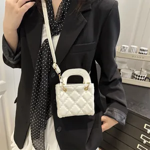 Petit sac blanc matelassé avec détails dorés porté par un mannequin en blazer noir