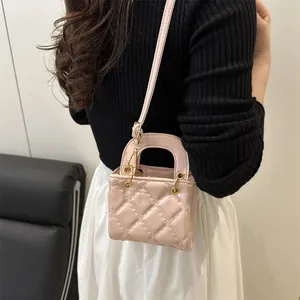 Elegant pink quilted mini crossbody bag with top handle and golden metal eyelets detail