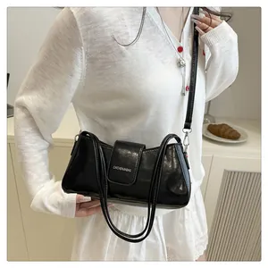 Detail shot of a black patent leather shoulder bag with CAICHENJIABAG logo branding