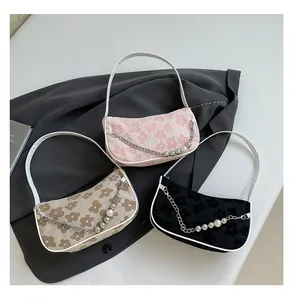 Detailed shot of three floral jacquard shoulder bags with pearl chains and leather trim