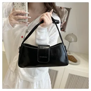 Fashionable black patent leather baguette bag shown in a cozy lifestyle setting