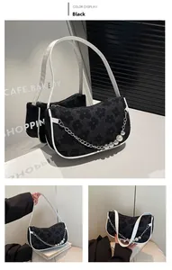Detail of black woven shoulder bag with white trim, pearl metal chain, and floral pattern