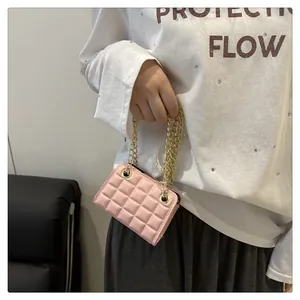 Detail van roze gewatteerde mini-tas met dubbele gouden kettinghandvatten en stiksel