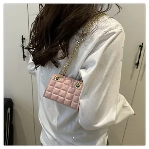 Gedragen beeld van een roze gewatteerde crossbodytas met gouden ketting
