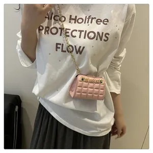 Close-up of pink quilted crossbody bag with gold chain strap and metal ring detail