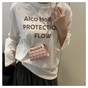 Detail van roze gewatteerde mini-crossbodytas met gouden ketting en ruitjespatroon