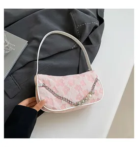 Detail of pink floral woven shoulder bag with pearl chain and silver bead accents