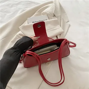 Glossy red patent leather underarm bag on chic beige blazer for a retro casual style