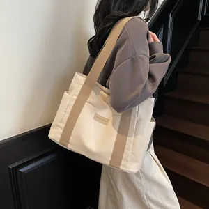 Borsa tote minimalista in tela bianco sporco con manici marroni e tasca laterale