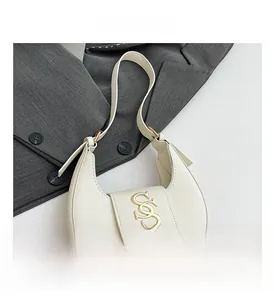 Dettaglio macro della borsa hobo bianca con finiture SOS dorate e nappa in pelle