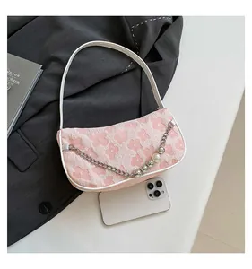 Detailed macro view of pink woven flower handbag with elegant pearl and metal chain accents