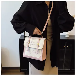 Borsa a mano crema e rosa con disegni di cartoni animati indossata dal modello