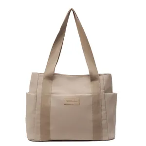 Borsa tote in tela beige minimalista di grande capacità con tasche laterali e etichetta