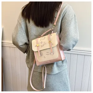 Dettaglio mini zaino rosa e beige con spallacci regolabili e stampa a cartoni