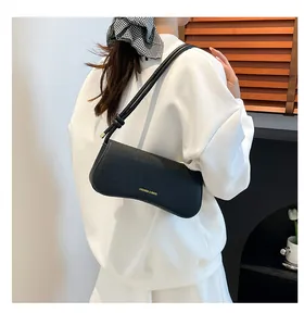 Sac à bandoulière en cuir litchi noir avec détail de nœud et silhouette incurvée
