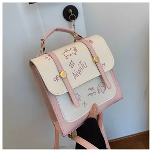 Dettaglio della borsa in pelle PU rosa e beige con graziose illustrazioni a fumetti