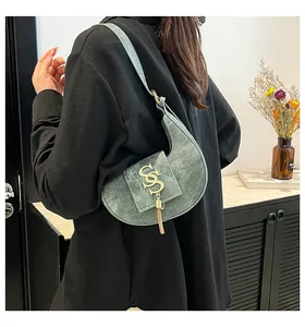 Borsa a mezzaluna verde con nappa dorata indossata da una modella in camicia nera