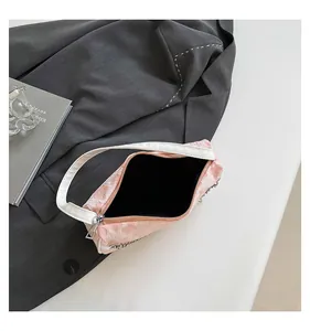 Detail of pink floral fabric bag showing silver zipper and black inner lining texture