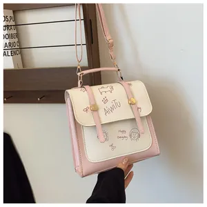Dettaglio borsa in pelle PU rosa e bianca con illustrazioni a fumetti e tracolla