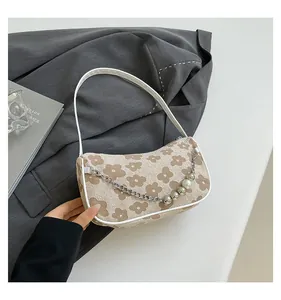 Detail of woven floral shoulder bag with pearl metal chain and white leather strap
