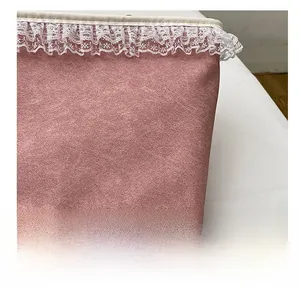 Détail du tissu en daim rose avec bordure en dentelle blanche et couture d'un sac