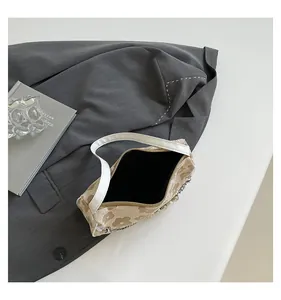 Detail shot of the floral fabric shoulder bag with pearl chain and zip opening