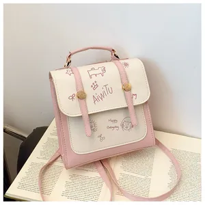 Dettaglio dello zaino in pelle PU rosa e bianca con motivi a cartoni animati e fibbie