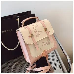 Dettaglio della borsa rosa e bianca con stampe graffiti e chiusure dorate in metallo