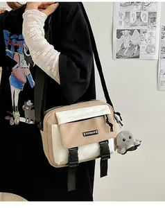 Detail of crossbody bag with beige contrast, front buckles and octopus plush charm