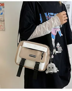 Detailed view of beige canvas crossbody bag with contrast buckle and cute octopus plush charm
