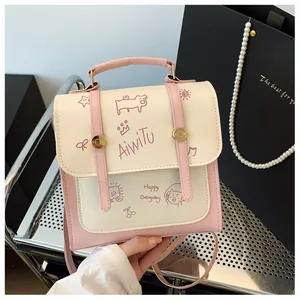 Dettaglio del mini zaino rosa e crema con grafiche cartoon e fibbia dorata
