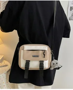 Detail of canvas messenger bag with contrast stitching and octopus plush keychain