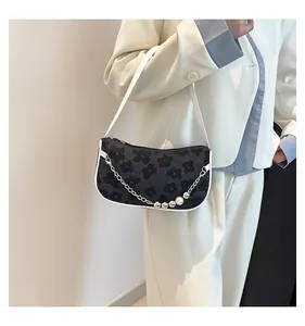 Detail of floral woven shoulder bag with pearl chain and elegant white leather trim