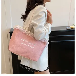 Détail du sac cabas en toile rose avec bordure en dentelle blanche et lettrage imprimé
