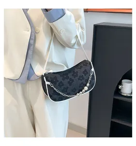 Detail of woven floral shoulder bag with silver chain and pearl decoration for women
