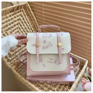 Dettaglio mini zaino in pelle PU rosa e bianca con motivi a cartone e finiture dorate