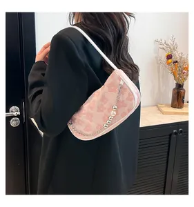 Detail showing pink floral fabric texture with beaded pearl chain on shoulder bag