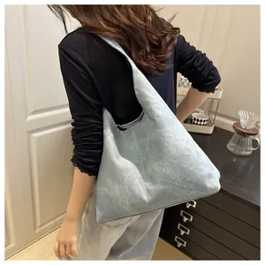 Detailed side view of light blue leather tote bag with marble texture worn by model