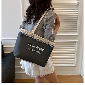 Détail du sac cabas en toile noire avec bordure en dentelle blanche et texte EVEA GLOW