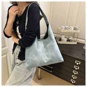 Close-up of light blue large tote bag with vintage wrinkled texture on wide shoulder strap